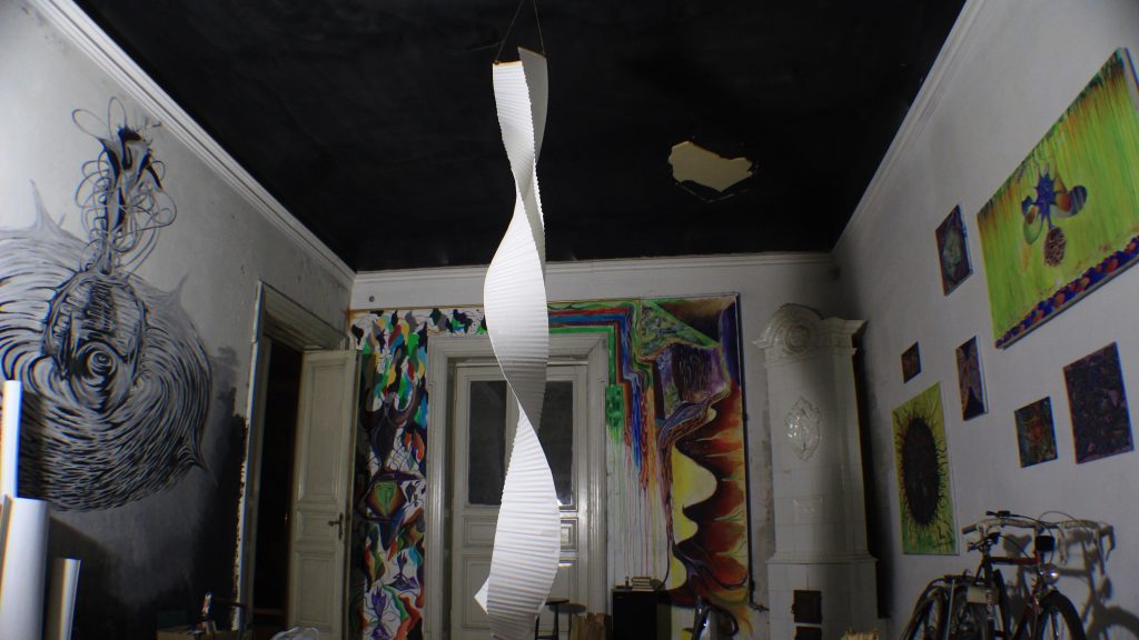 Interior of Daniel Gaciu’s atelier with paintings and a white hanging sculpture