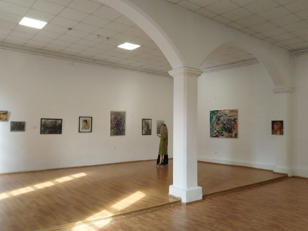 Sală albă de expoziție cu arcade și picturi de Daniel Gaciu, Târgu Jiu